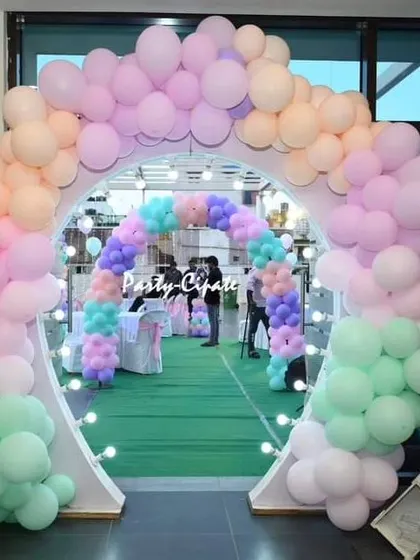 A grand double balloon arch in pastel colors creates a tunnel effect for guests entering Samhita's party. It's a great way to make a big impact.