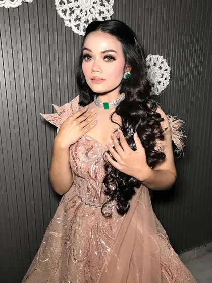 A close-up showing the intricate details of the makeup and jewelry.