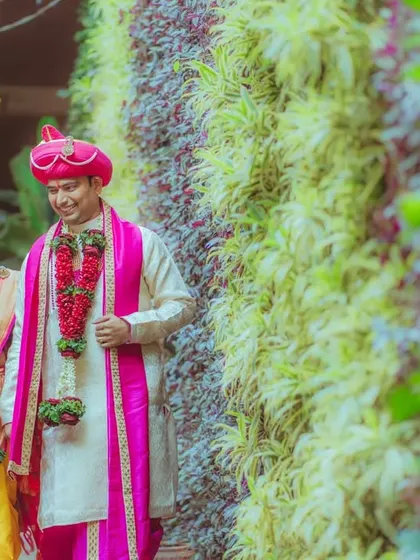 The bride and groom walking into their future together. This photo captures the movement and happiness of the couple against a vibrant green wall.