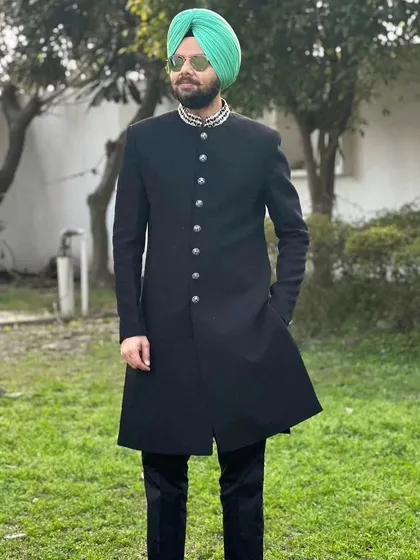 Comedian Jaspreet Singh in our black Indo-western outfit, standing confidently in a garden setting.