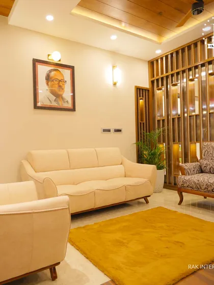 This living area features a beautiful wooden partition with metallic accents, creating a subtle separation of space. The warm tones and personal portrait make it feel cozy and lived-in.