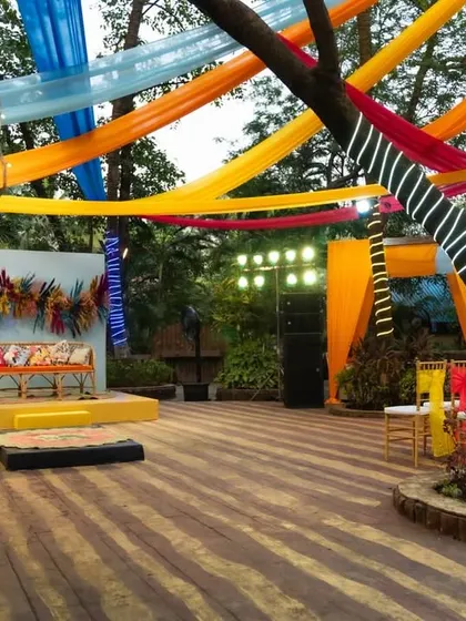 The stage area for the carnival-themed party featured a colorful backdrop and bright lighting, with trees wrapped in lights to enhance the festive mood.