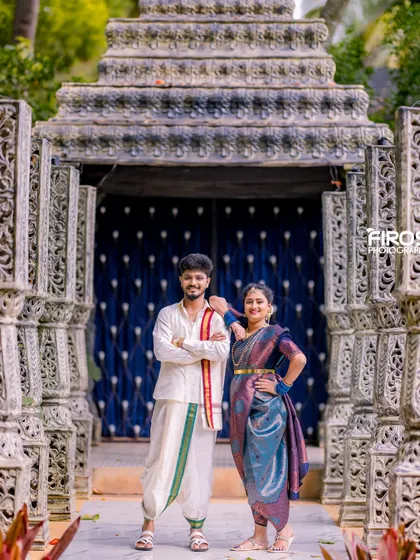 A stylish pose of a couple in traditional Kodava attire in front of our stone pillar set.