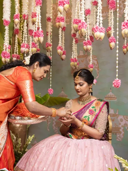A tender moment between mother and daughter during a pre-wedding ceremony. The beautiful decor provides a worthy backdrop for these precious family interactions.