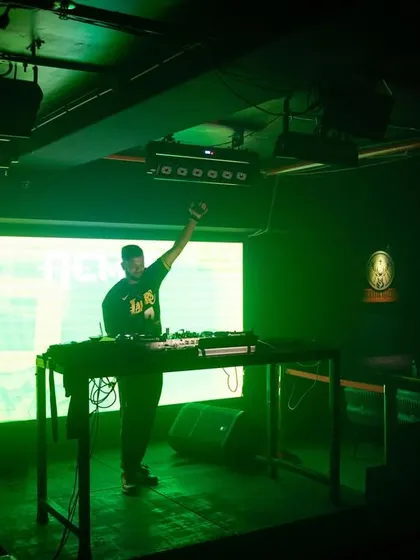A full-stage view at Cyclone Club, with me commanding the audience under bright green lights.