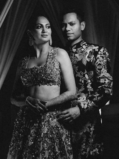 A dramatic black and white portrait of Ankita and Anurag, their heavily embellished outfits captured with bold, contrasting light.