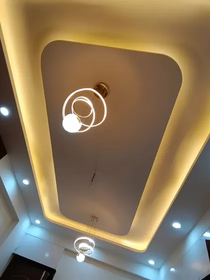 Another angle of the clean and modern false ceiling design, which provides both ambient and focused light through its cove and spotlights.