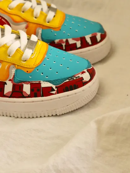 A detail of the toe box on the multi-color drip AF1s. The design even includes a painted cityscape, adding another layer of artistry to the shoe.
