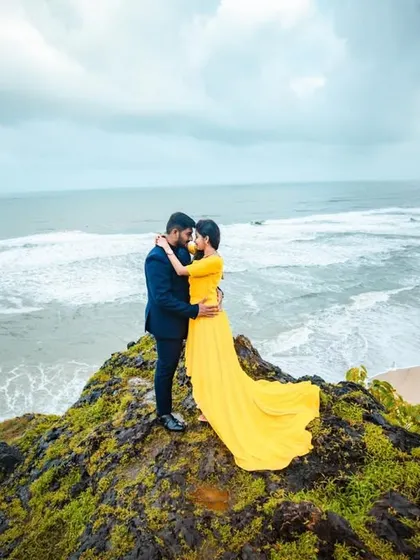 A dramatic pre-wedding shot of a couple on a mossy cliff overlooking a vast, churning sea. This image highlights our expertise in destination wedding photography, using natural landscapes to create breathtaking portraits.