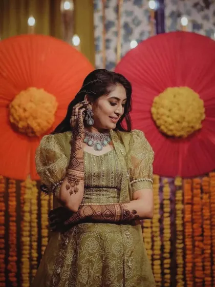 A gorgeous shot of a bride at her mehndi function. The design on her arms is visible, adding to her overall festive look.