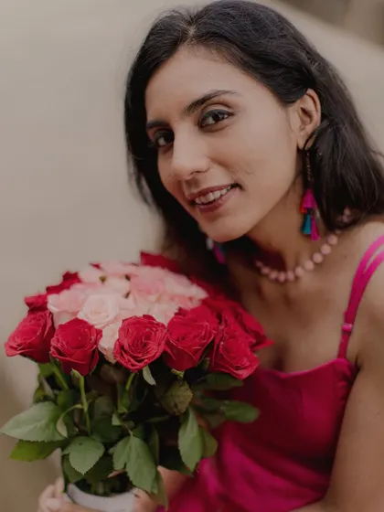A beautiful portrait of the bride-to-be holding a bouquet of roses, her smile lighting up the frame.