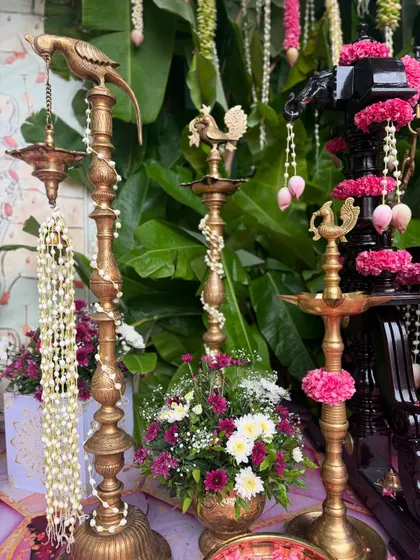 A close-up of the traditional brass lamps (diyas) adorned with flowers, a key element in our South Indian decor.