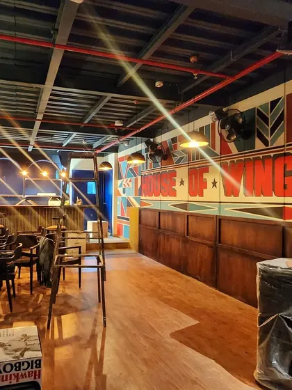 A wide view of the "House of Wings" restaurant interior, where our geometric mural serves as a dynamic backdrop for the entire space.