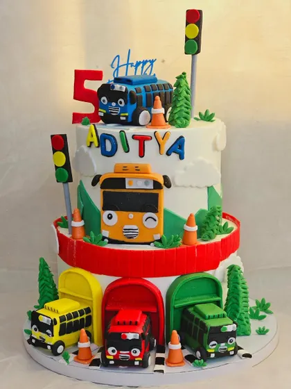 All aboard the Tayo bus. This two-tier cake features the friendly little bus and his friends, complete with their colorful garages, traffic cones, and signals for a fun city adventure.
