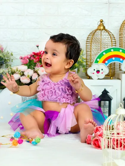 A big, joyful laugh. This candid moment captures the pure happiness of a child playing in a beautiful, flower-filled setting.