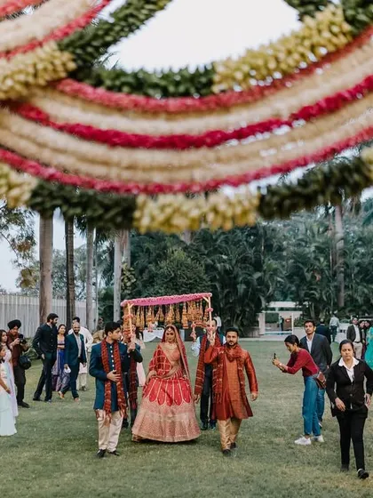 The bride's entrance under a beautiful floral canopy. This low-angle shot emphasizes the grandeur of the decor and the moment.