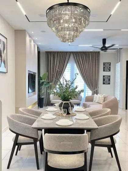 A compact yet elegant dining space that opens directly into the living room. We used a tiered crystal chandelier and framed art to give the area its own distinct character within the open-concept layout.
