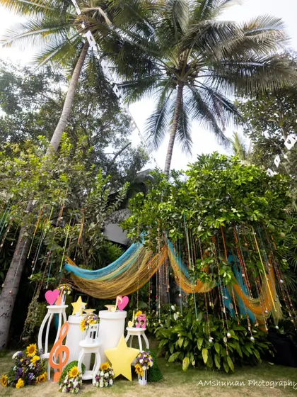 A full view of the musical garden setup, with colorful drapes, hanging bells, and themed props creating a vibrant and playful atmosphere for an outdoor birthday party.