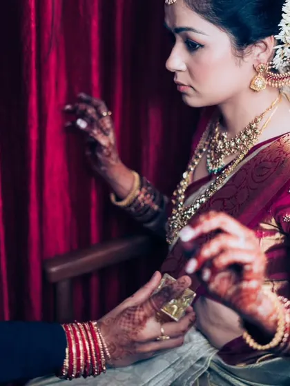 A behind-the-scenes shot of the bride getting her traditional waist belt (kamarbandh) adjusted, a key part of her South Indian bridal attire.