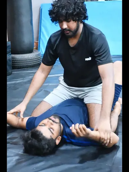 A coach demonstrating a grappling technique to a student. We focus on detailed instruction to ensure our students learn correctly.