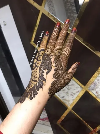 A detailed design on the back of the hand, combining leafy vines with traditional Indian motifs.