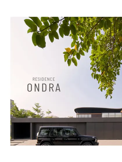 The entrance to Residence Ondra in Amritsar is intentionally discreet, concealed behind a monolithic wall. This design choice ensures complete privacy from the street, with only a hint of the sweeping architectural forms that lie beyond.