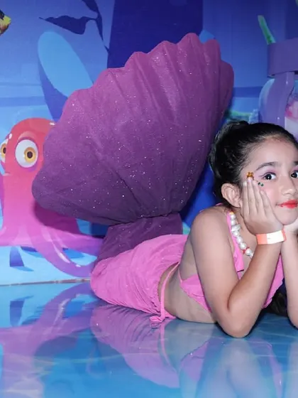 A girl poses in a beautiful mermaid costume in our underwater-themed spa and photo area.