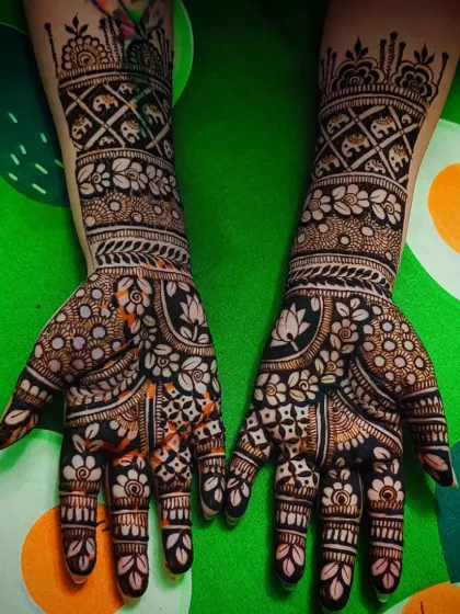 A beautiful design featuring elephant motifs on the forearm and dense floral patterns on the palm.