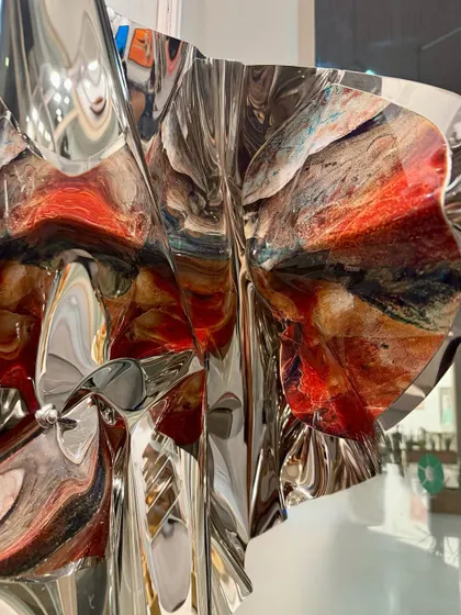 A surprise detail on the interior fold of the sculpture reveals a burst of abstract, earthy colors.