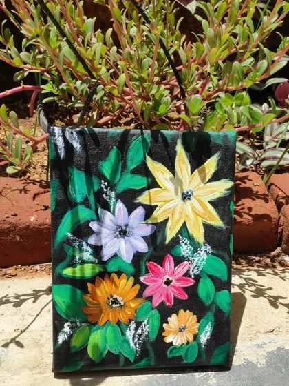 A close-up of the floral painting amidst green foliage.