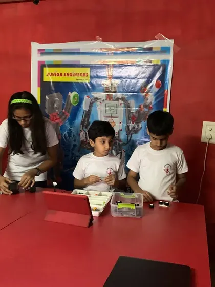 Students work together at a table, sorting parts and building their robots. This image captures the collaborative and focused atmosphere of our classes.