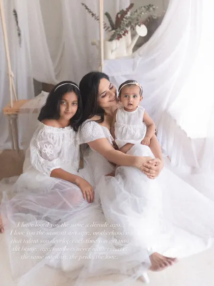 A serene portrait of a mother with her two daughters, dressed in coordinated white outfits. This image speaks to the gentle, powerful bond of motherhood and sisterhood.