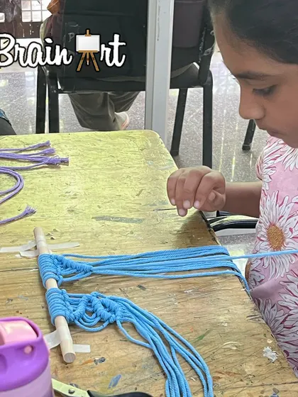 Learning to keep tension in the cords is a key part of macrame. This student is doing a fantastic job as she builds her pattern.
