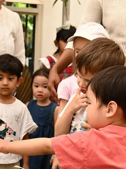 A child reaches out to touch the fishbowl, a moment of pure curiosity and wonder.