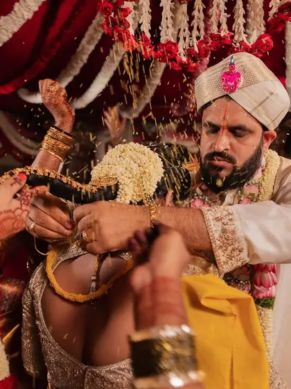 An intense, emotional close-up of a key moment in a South Indian wedding ceremony, with the family's hands joining in the ritual.