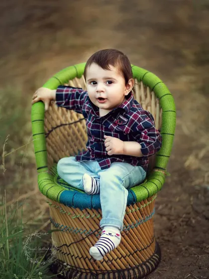 A toddler looking cool and confident in a small cane chair outdoors. I love capturing the big personalities of these little explorers.
