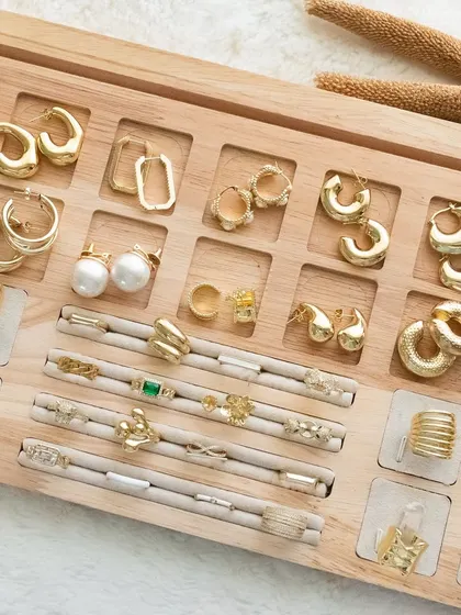 A wide shot of our accessory tray, filled with a variety of our anti-tarnish and waterproof earrings and rings, ready to be styled.