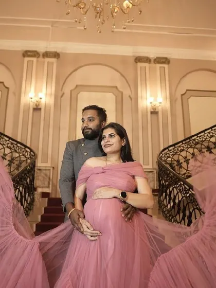A beautiful maternity shoot featuring our custom pink off-shoulder gown with a dramatic trail.