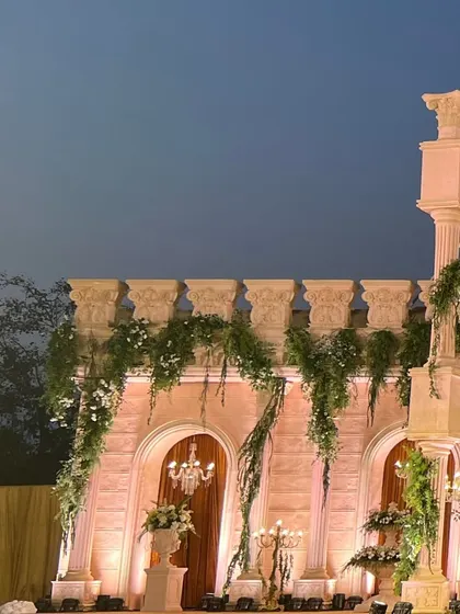 The side view of the Roman-inspired mandap at dusk, with soft lighting creating a romantic and historic ambiance.
