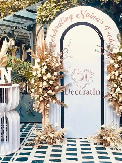 A beautiful boho-chic setup for Naina's 40th birthday. The custom white arch is elegantly framed with arrangements of pampas grass and white roses, creating a sophisticated and natural photo backdrop.