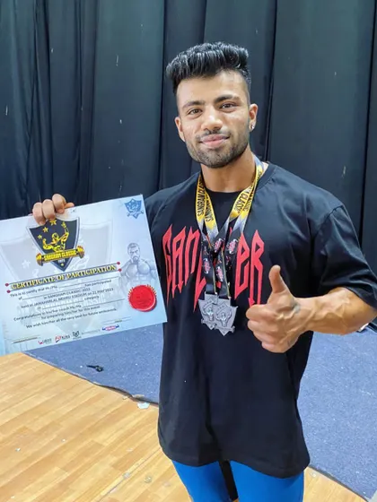 I made it to the top 10 out of over 70 athletes in my category. Holding my certificate and medal after a tough competition in Delhi.
