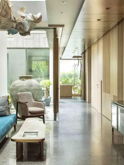 This wide shot of the family lounge shows how the large-scale origami installation commands the space above, while the curated furniture and art below create a warm, communal environment.