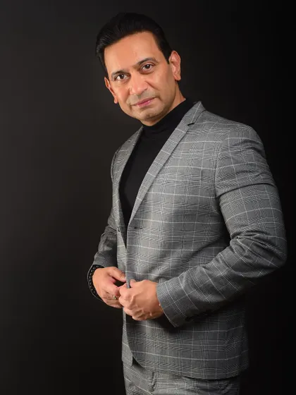 A modern professional look with a turtleneck and a plaid suit. This shows a keen sense of style and is perfect for leaders in creative or fashion-forward industries.