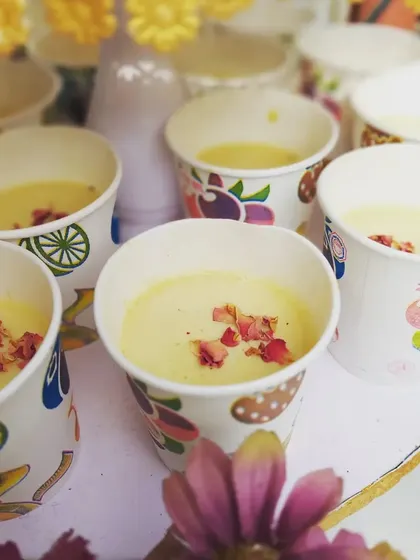 A close-up of our creamy thandai, garnished with rose petals for a touch of elegance. This traditional drink is a highlight of our Holi celebration menus.