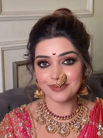 A direct look from the bride, showing off the flawless base, defined eyes, and traditional jewelry.