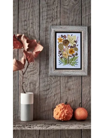 One of my pressed flower pieces, framed and styled on a rustic wooden shelf. This shows how beautiful they look as part of your home decor.
