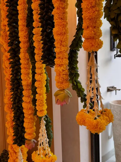 There's something so special about traditional housewarming decor. Here, I've used classic genda phool (marigold) garlands with delicate jasmine tassels to create a warm and auspicious welcome for a new beginning.