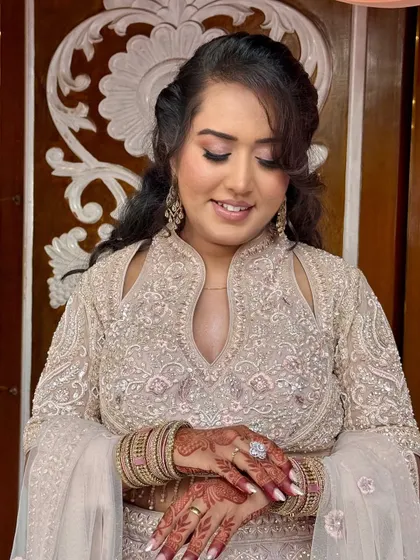 A close-up of the bride admiring her henna. The makeup is soft and romantic.