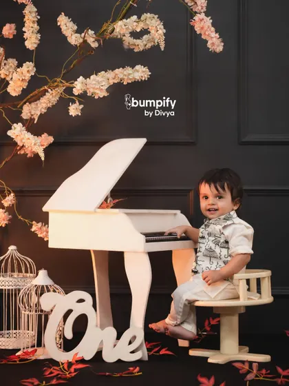 Let's celebrate your little one's first year with a creative theme. This mini maestro setup with a tiny piano and elegant decor is a unique way to mark the occasion and create truly memorable first birthday photos.