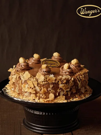 For all the chocolate lovers, our Nutella Hazelnut Cake is pure indulgence. It features a rich chocolate sponge, a creamy Nutella frosting, and a crunchy layer of wafer flakes, all topped with whole roasted hazelnuts.